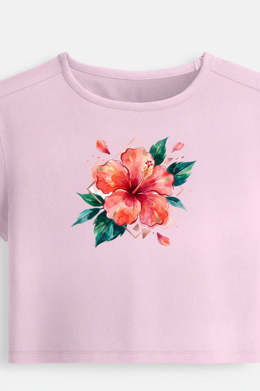 A light pink short-sleeve crop top featuring a vibrant watercolor hibiscus flower graphic in orange and red with green leaves on the center chest, displayed against a clean off-white background.